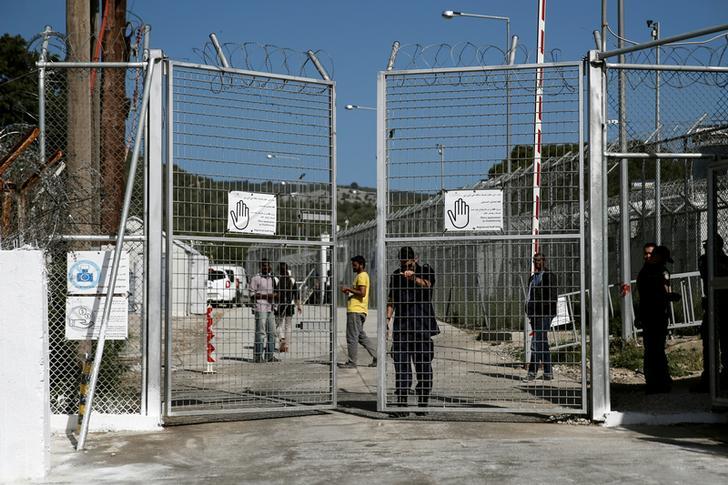 A police officer closes the gate of the Moria holding centre for refugees and migrants, which Pope Francis will visit on April 16 on the Greek island of Lesbos.