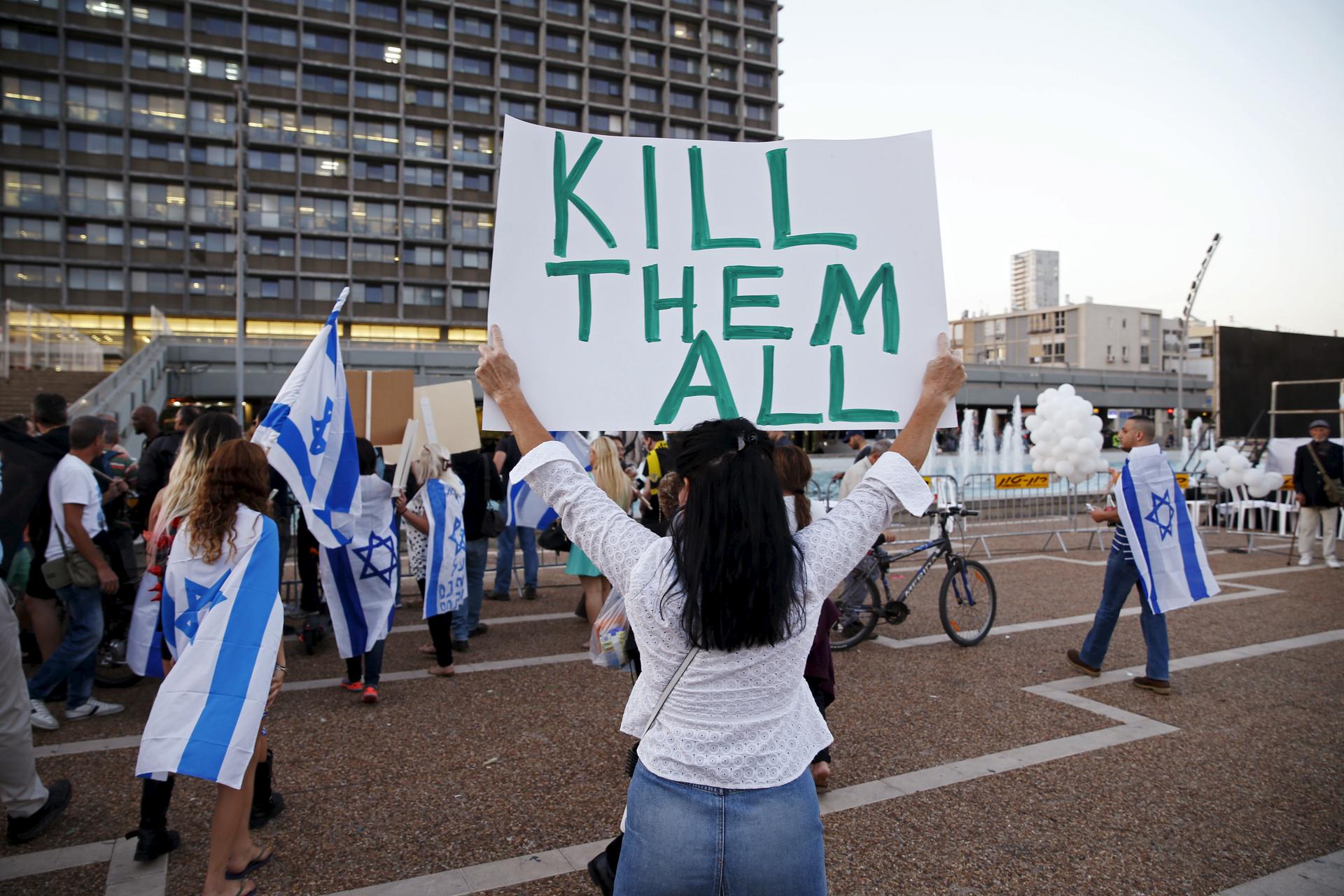 A supporter of Isralei solder Elor Azaria in Tel Aviv holds a sign saying "Kill them all" on April 19, 2016.