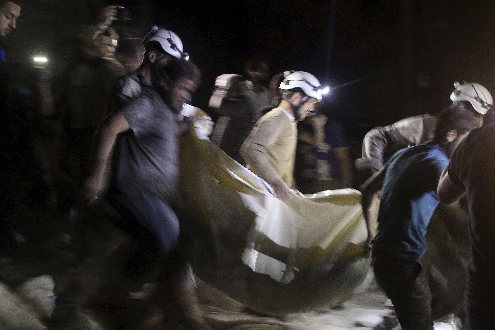 Civil defense members carry a casualty after an airstrike in the rebel held area of al-Sukari in Aleppo.