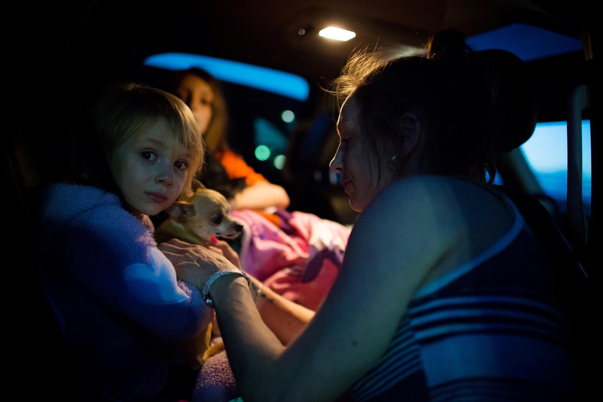 Fort McMurray resident Crystal Maltais buckles in her daughter, Mckennah Stapley, as they prepare to leave Conklin, Alberta, for Lac La Biche after evacuating their home in Fort McMurray on Tuesday May 3, 2016.