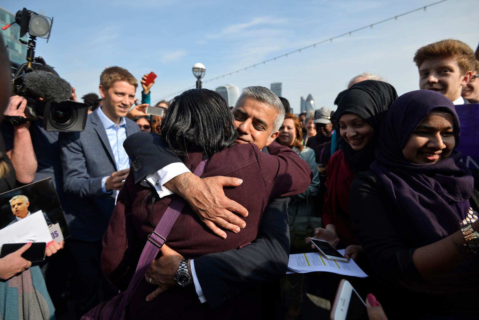 Britain's newly elected mayor Sadiq Khan is embraced by a supporter as he arrives for his first day at work at City Hall in London, Britain May 9, 2016.