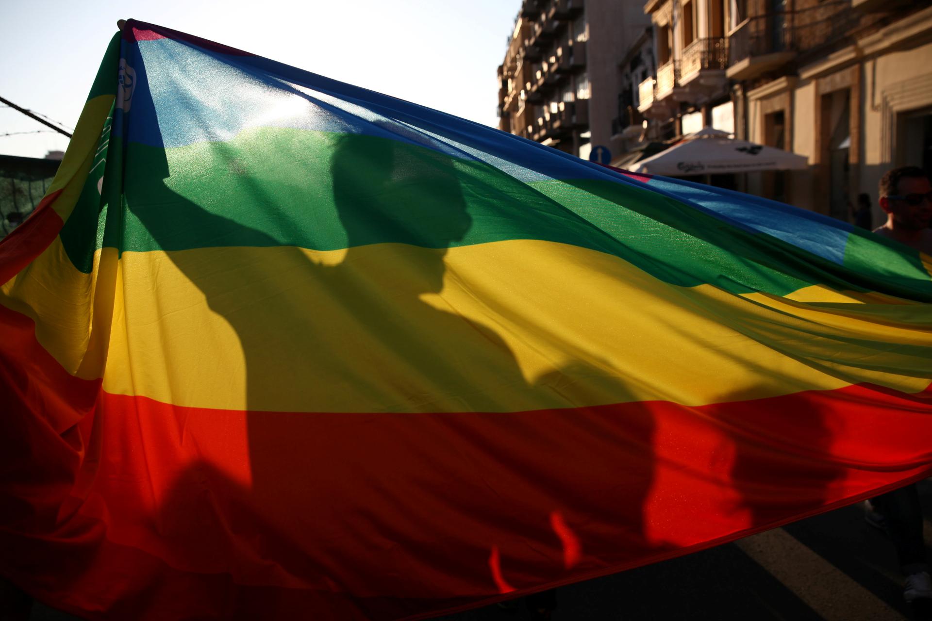 Participants are silhouetted while holding a rainbow flag during the annual gay pride parade in central Nicosia, Cyprus May 29, 2016.