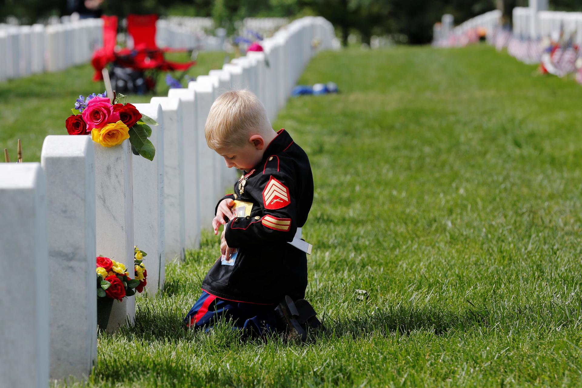 Christian Jacobs touches a photograph of his U.S. Marine father, Christopher Jacobs, while visiting his grave on Memorial Day at Arlington National Cemetery in Washington, U.S., May 30, 2016.