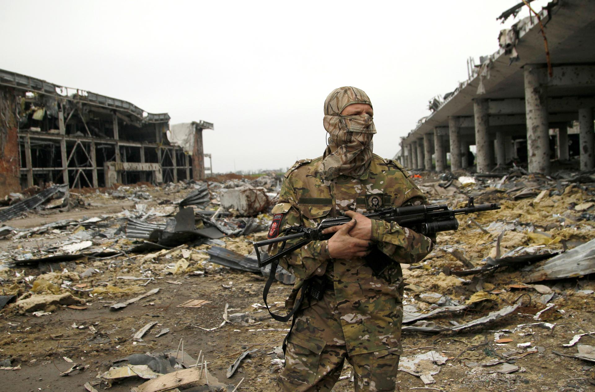 A pro-Russian rebel soldier stands guard near buildings destroyed during battles with Ukrainian armed forces, at Donetsk airport, Ukraine, June 1st 2016.