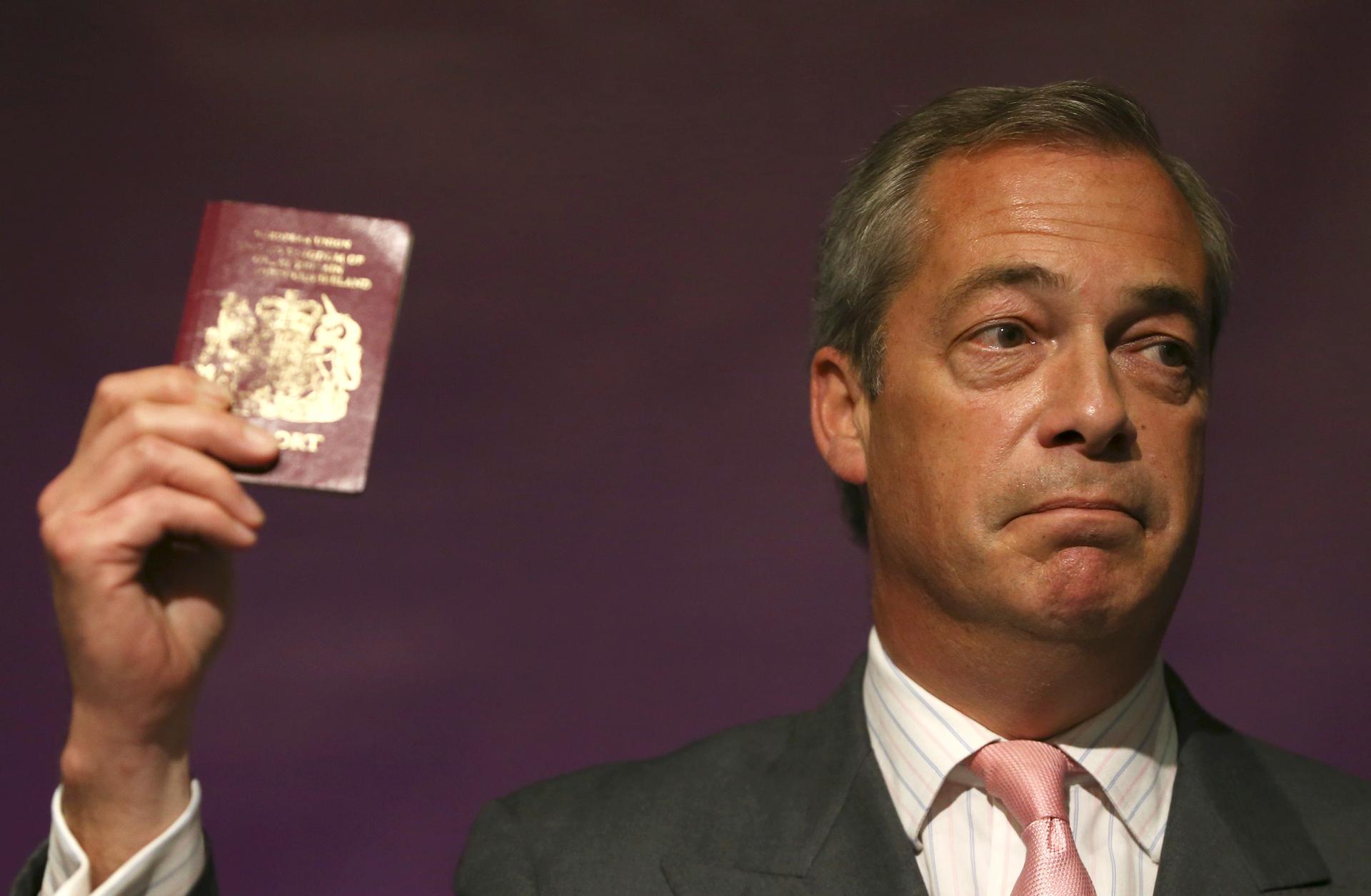 Leader of the United Kingdom Independence Party (UKIP) Nigel Farage holds his passport as he speaks at pro Brexit event in London, Britain June 3, 2016. 