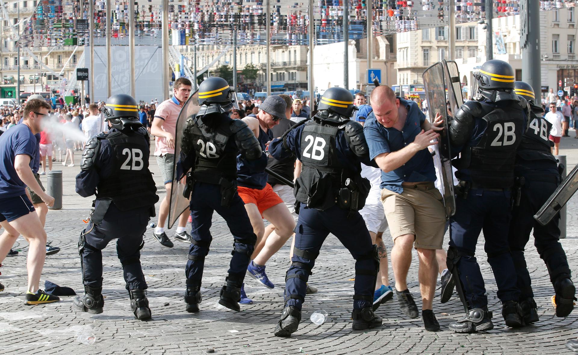 Police break up a fight between rival supporters at the old port of Marseille before the game.