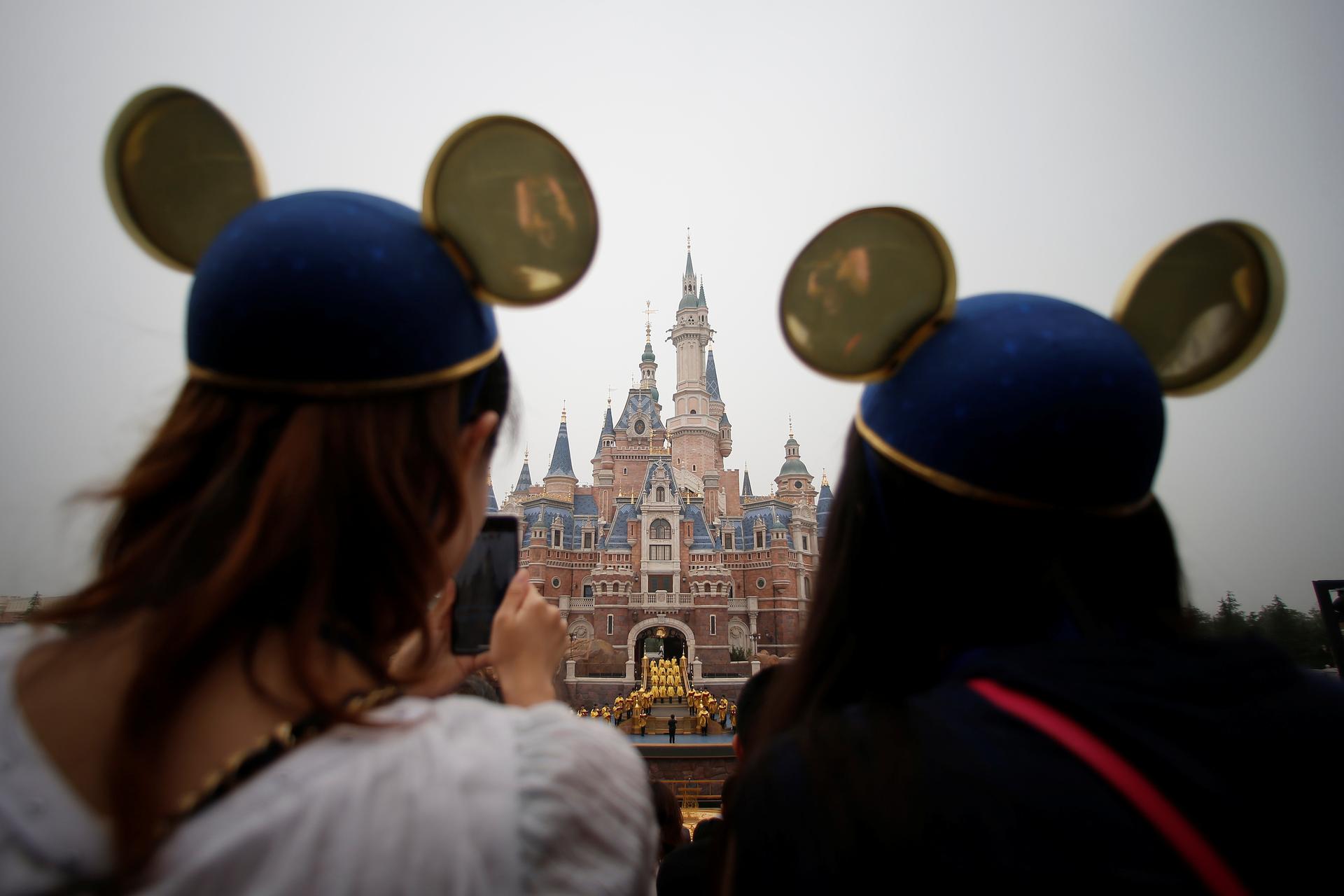 Women wearing Mickey Mouse ears watch the opening ceremony at Shanghai Disney Resort in Shanghai, China, June 16, 2016. 