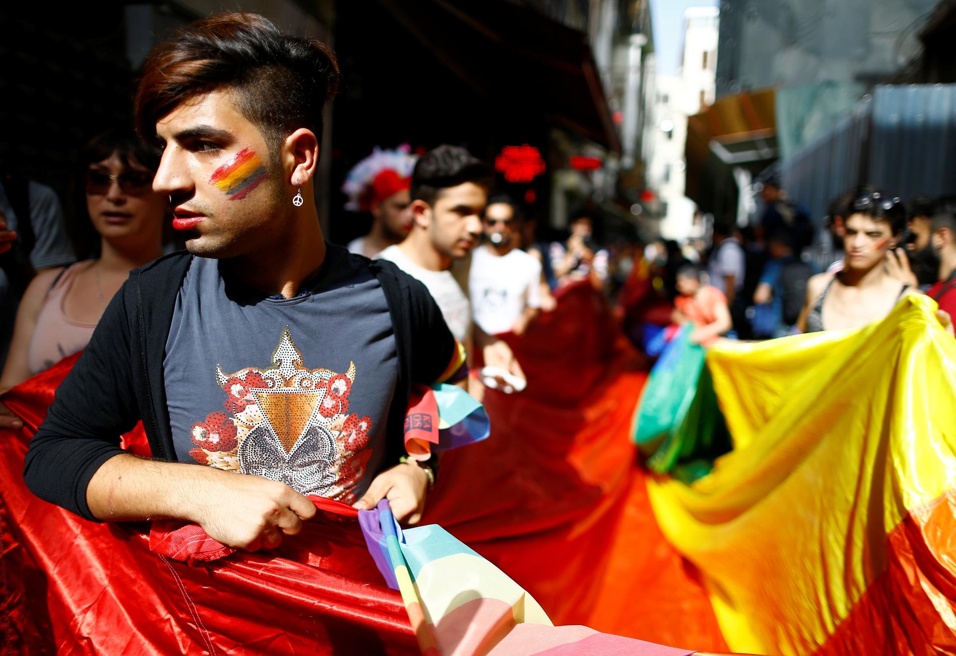 LGBT rights activists hold a rainbow flag during a transgender pride parade which was banned by the governorship, in central Istanbul, Turkey, June 19, 2016