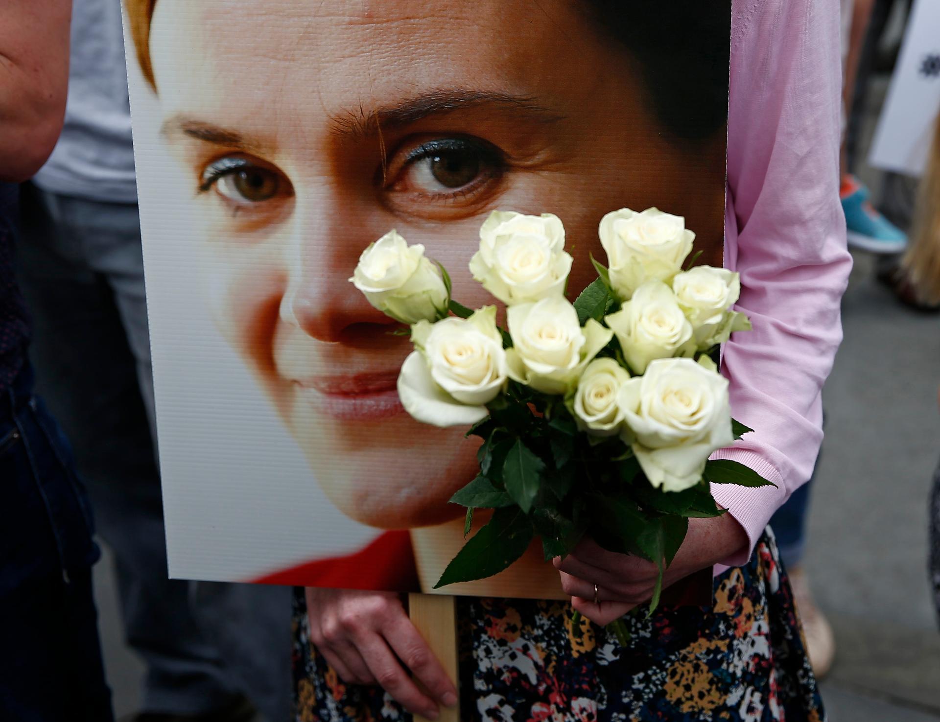 A woman holds a placard and white roses during a special service for murdered Labour Party MP Jo Cox, at Trafalgar Square in London, Britain June 22, 2016.