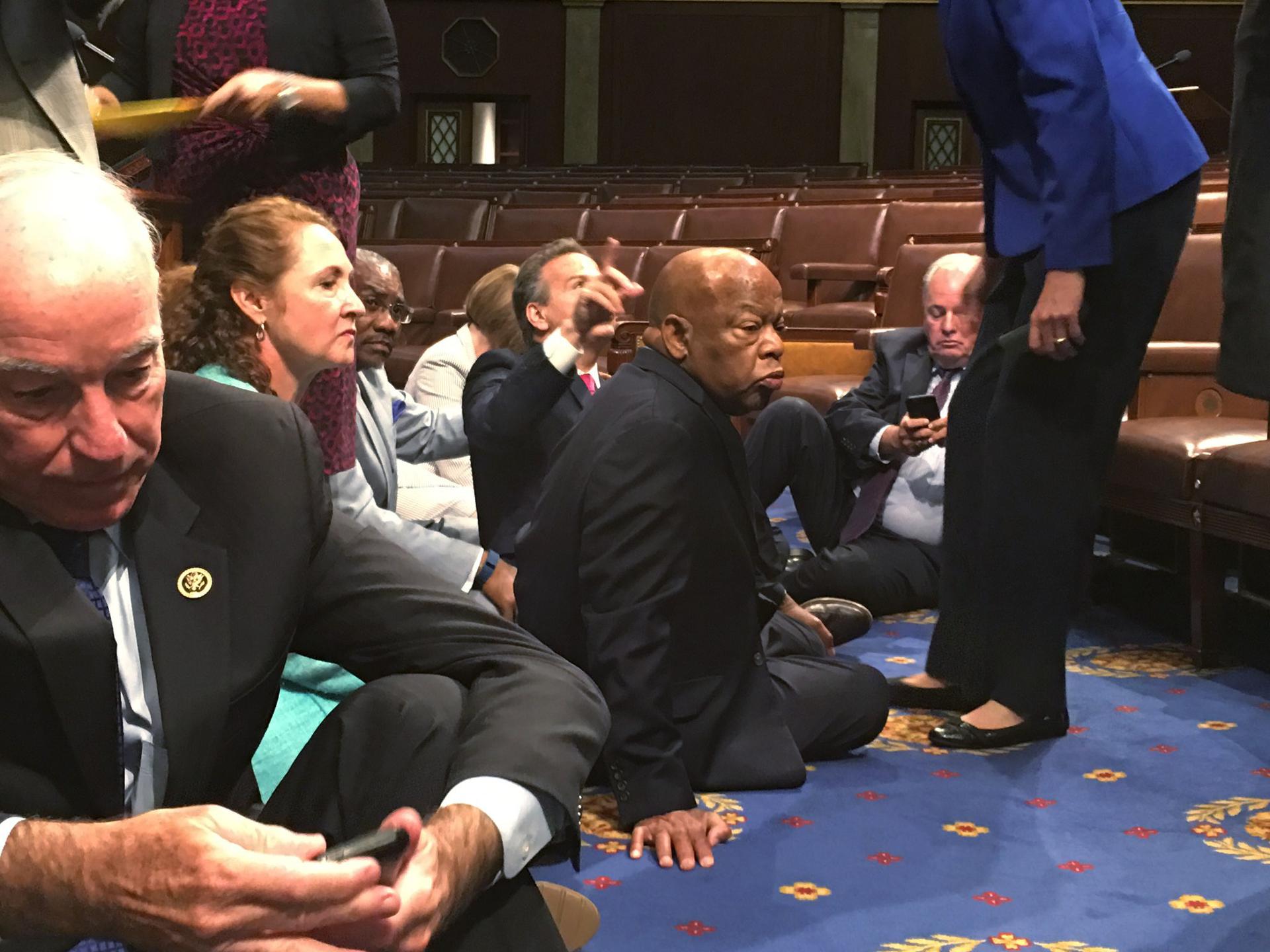 A photo shot and tweeted from the floor of the House by U.S. House Rep. John Yarmuth shows Democratic members of the U.S. House of Representatives, including Rep. Joe Courtney (L) and Rep. John Lewis (C) staging a sit-in on the House floor "to demand acti
