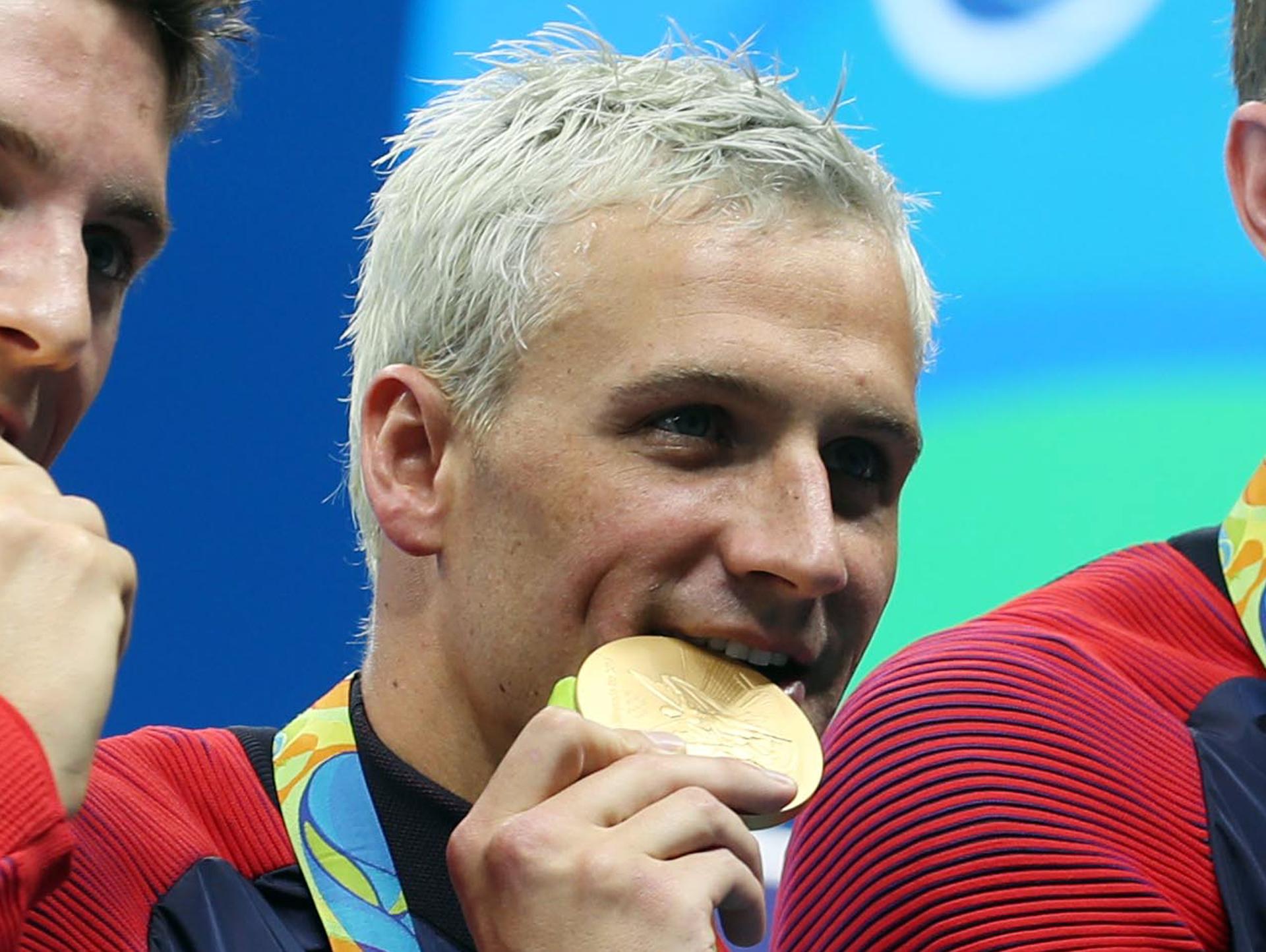 Ryan Lochte, the US swimmer, bites his Olympic gold medal in Rio de Janeiro.