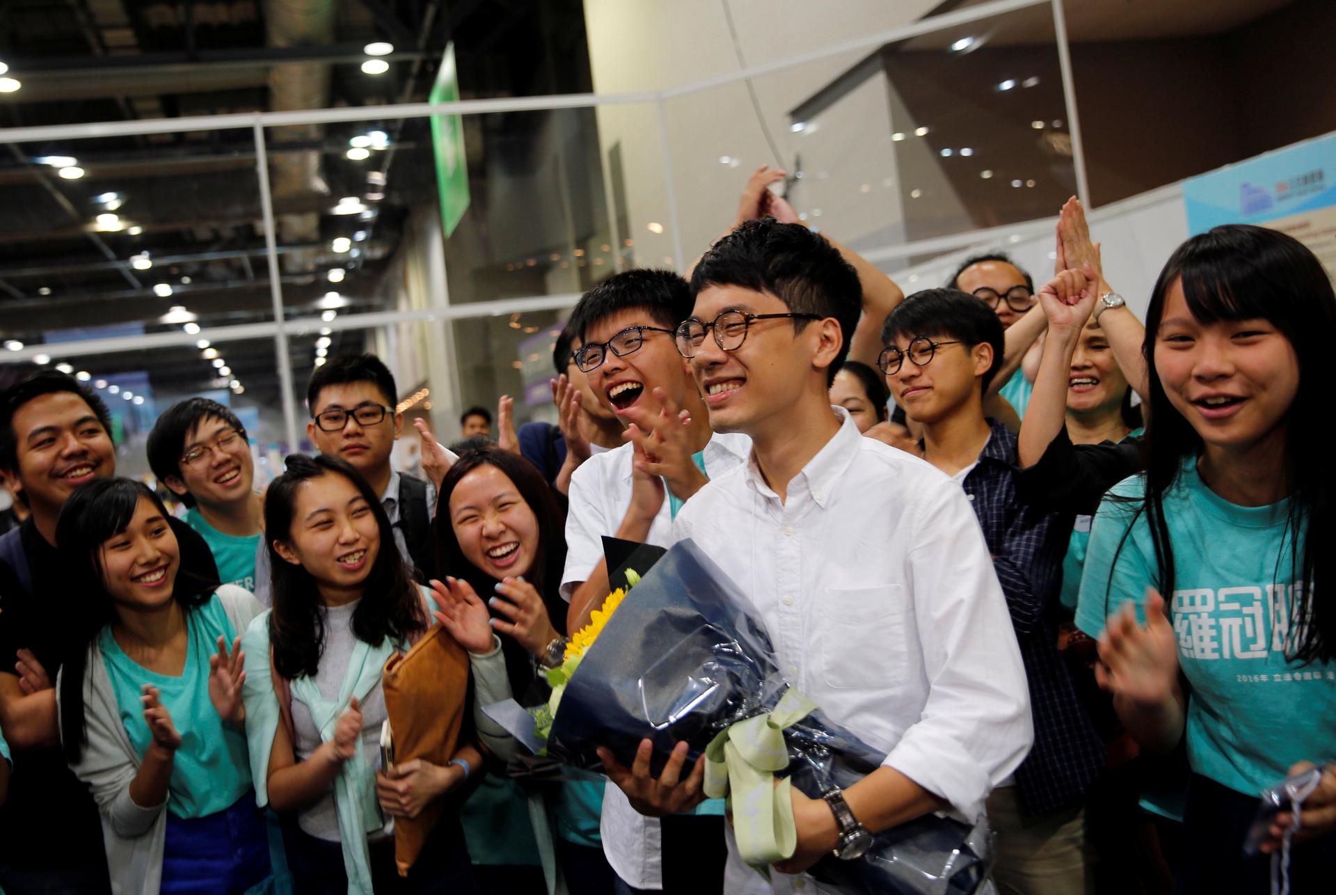Student leader Joshua Wong (C) greets candidate Nathan Law (2nd R) as supporters share their joy after Law won in the Legislative Council election in Hong Kong, China September 5, 2016.