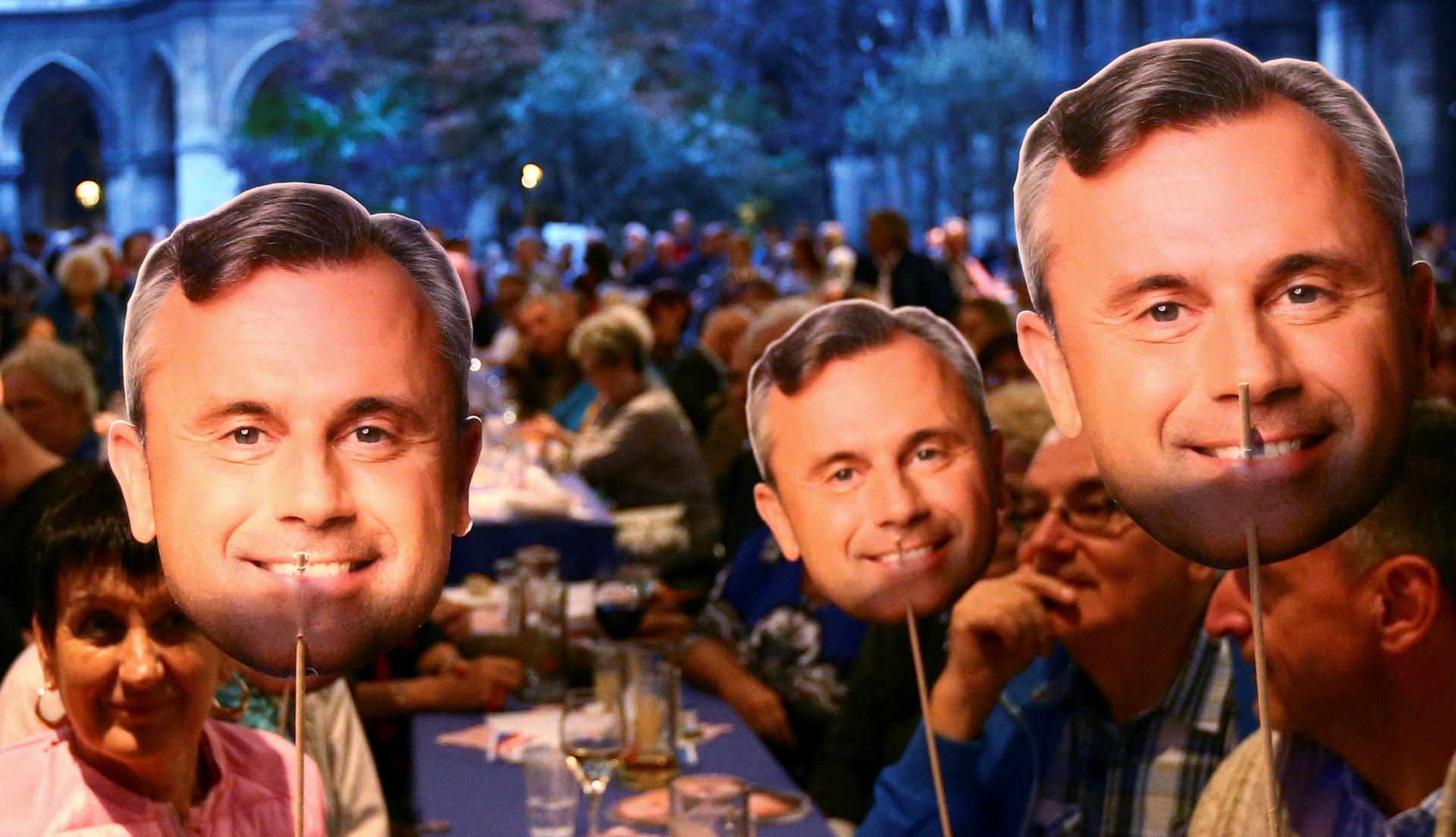 Supporters of Austrian far right Freedom Party (FPOe) presidential candidate Norbert Hofer hold images of his face in Vienna, Austria.
