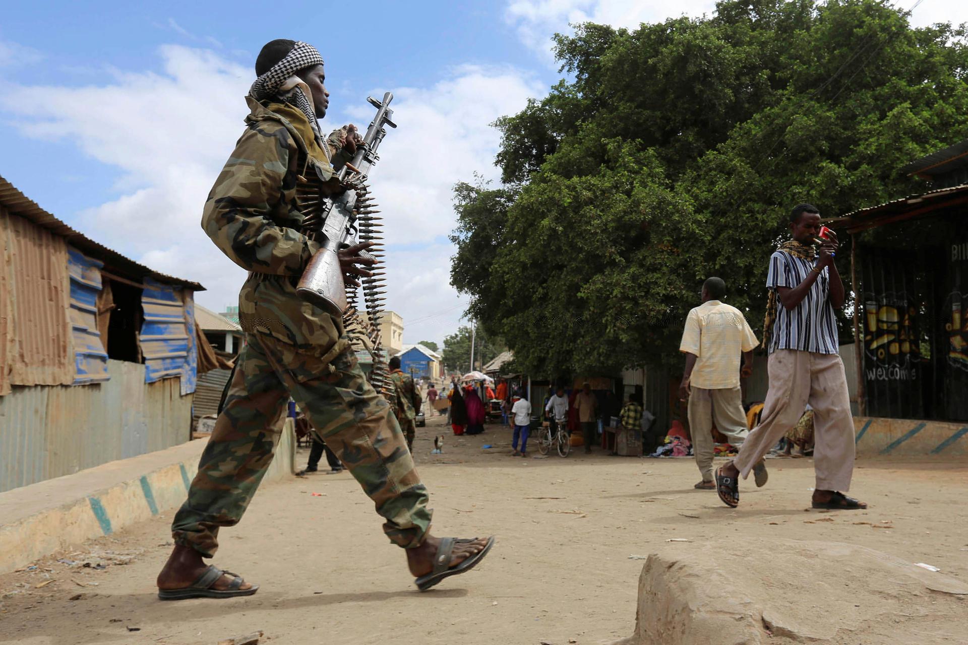 A Somali soldier patrols a street following a suicide car bomb and gun attack.