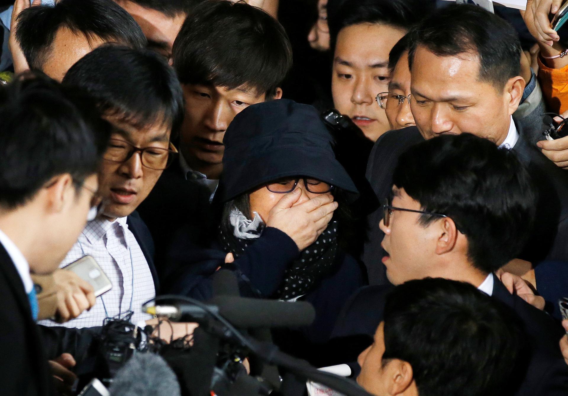 ​Choi Soon-sil (C), who is involved in a political scandal, reacts as she is surrounded by media upon her arrival at a prosecutor's office in Seoul, South Korea, October 31, 2016.