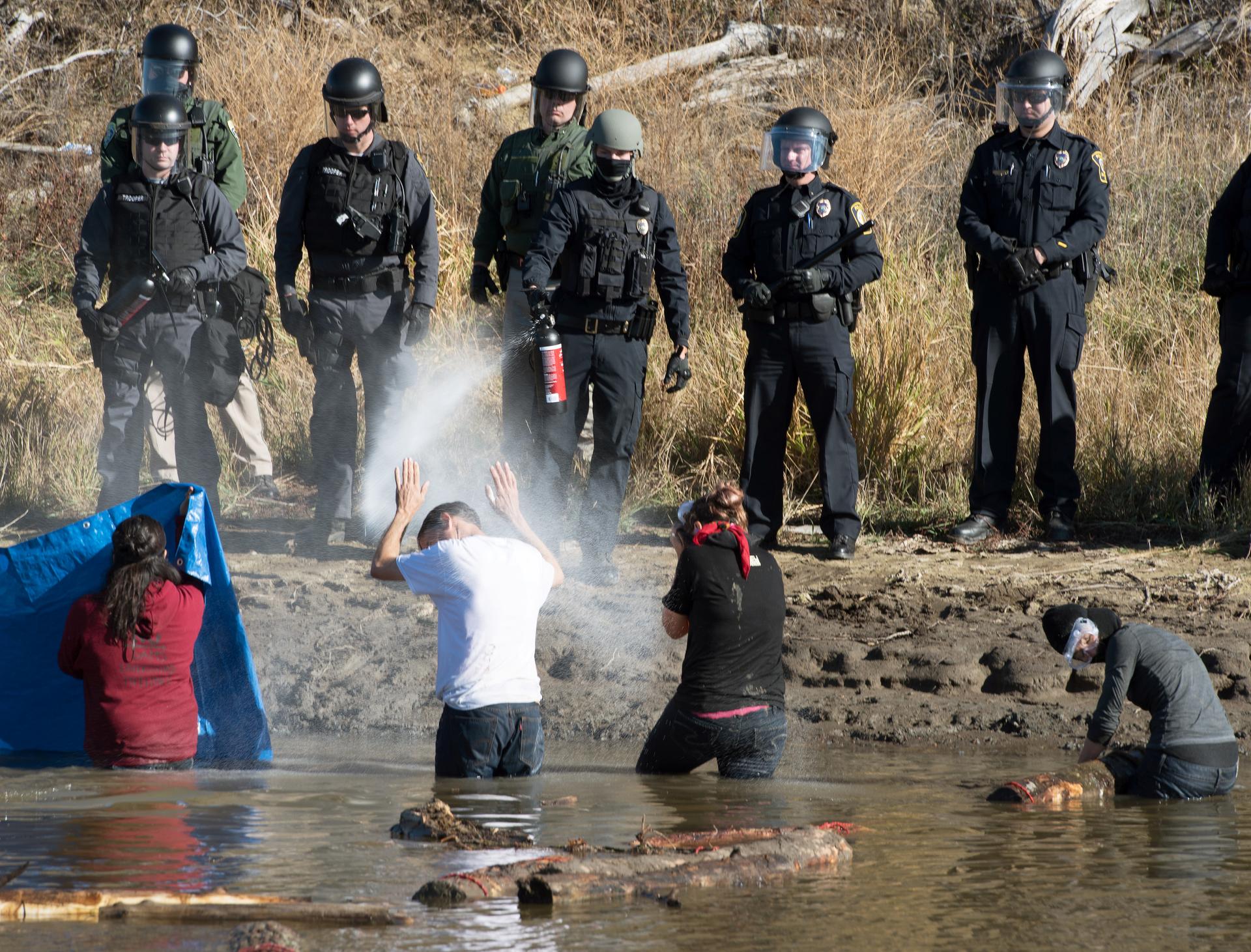 Police use pepper spray against protesters trying to cross a stream near an oil pipeline construction site near Standing Rock Indian Reservation, north of Cannon Ball, North Dakota, U.S. November 2, 2016.
