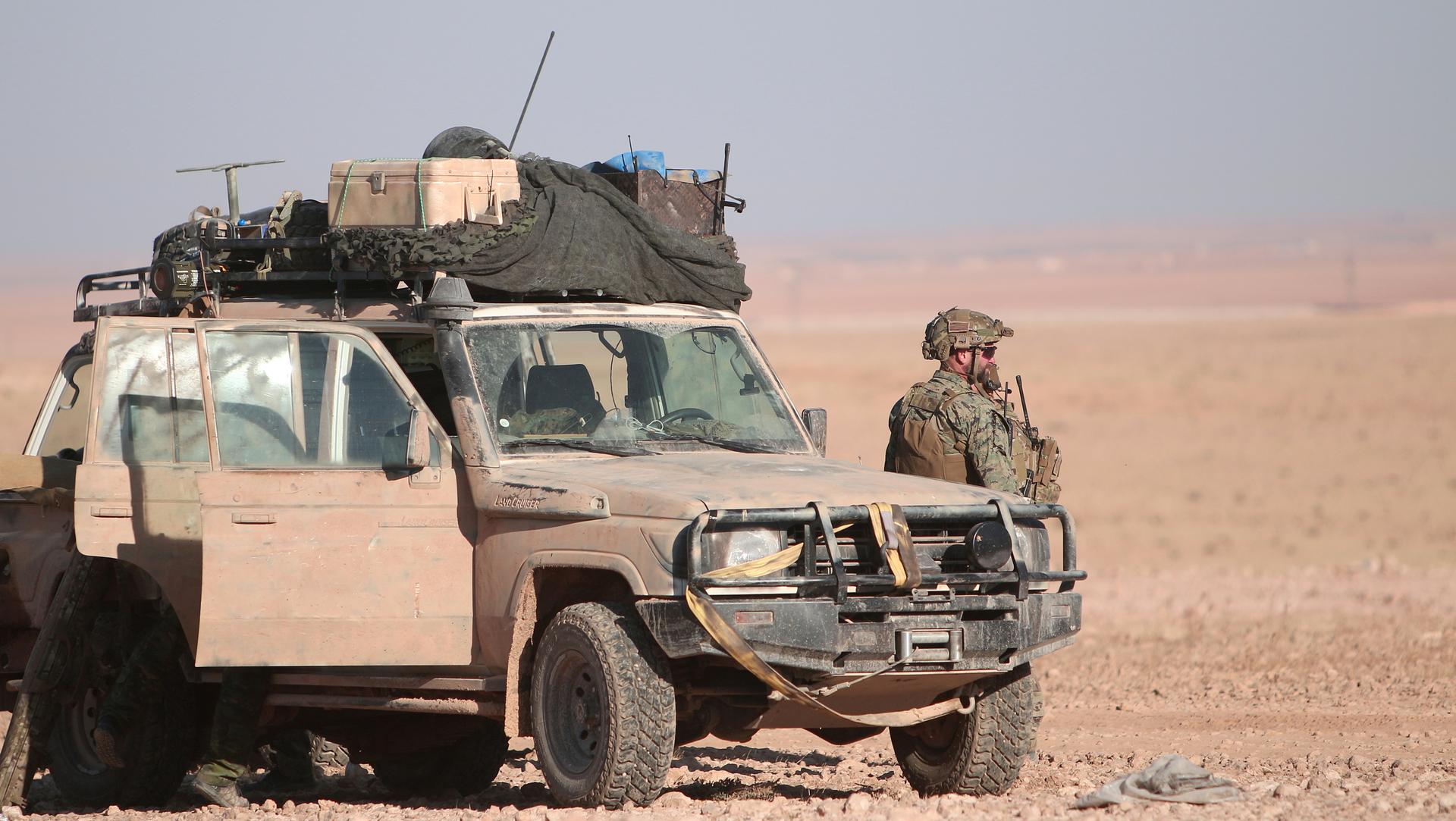 A US armed forces member stands near a military vehicle, north of Raqqa, Syria on Nov. 6.