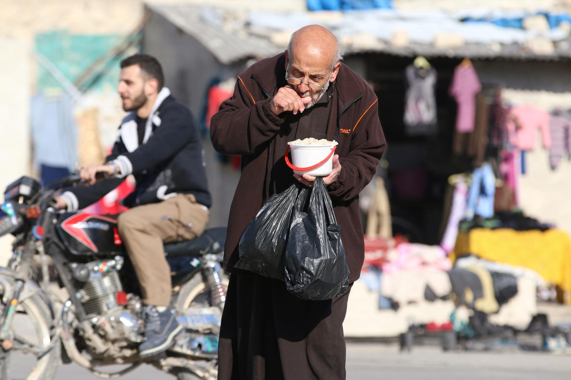 A man eats food distributed as aid in rebel-held eastern Aleppo, Syria, on Nov. 6, 2016.