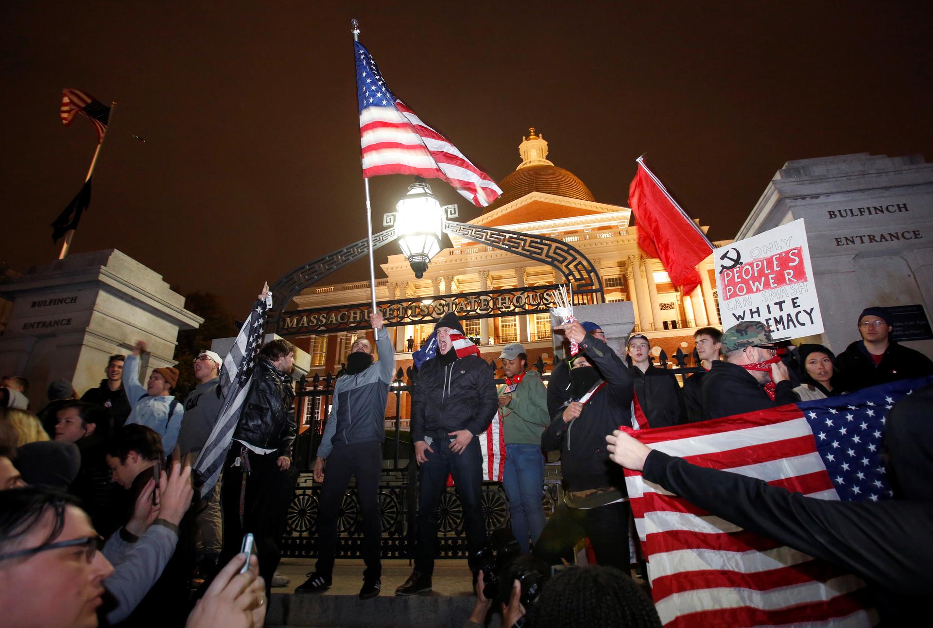 Protesters stand on the state house steps during a march in opposition to the election of Republican Donald Trump as President of the United States in Boston, Massachusetts, U.S. November 9, 2016.