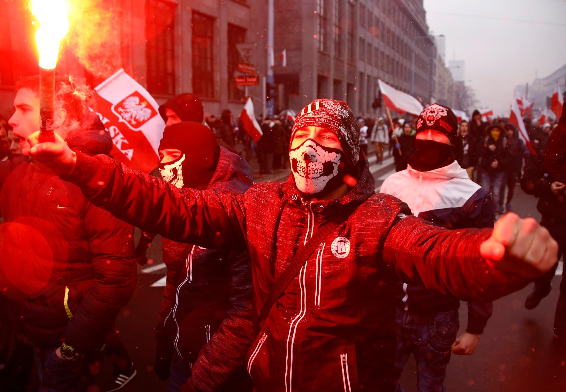 Protesters light flares and carry Polish flags during a rally, organised by far-right, nationalist groups, to mark the anniversary of Polish independence in Warsaw. 