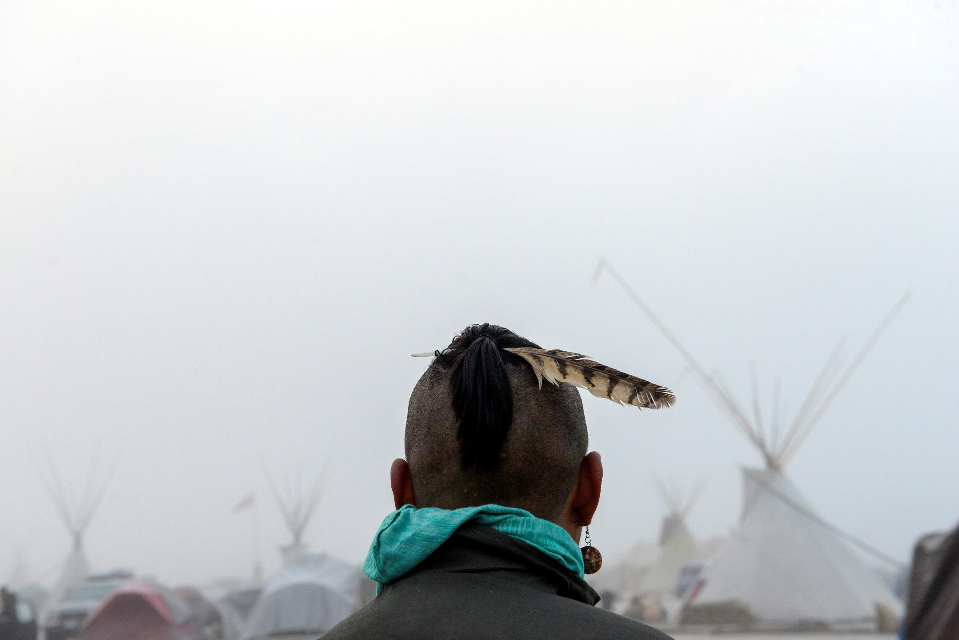 A man from the Muskogee tribe looks at the Oceti Sakowin shrouded in mist during a protest against the Dakota Access pipeline near the Standing Rock Indian Reservation.