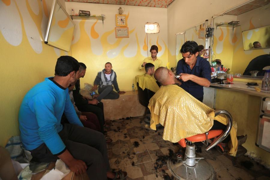 Iraqi men at a barber shop in the Intisar district of Mosul
