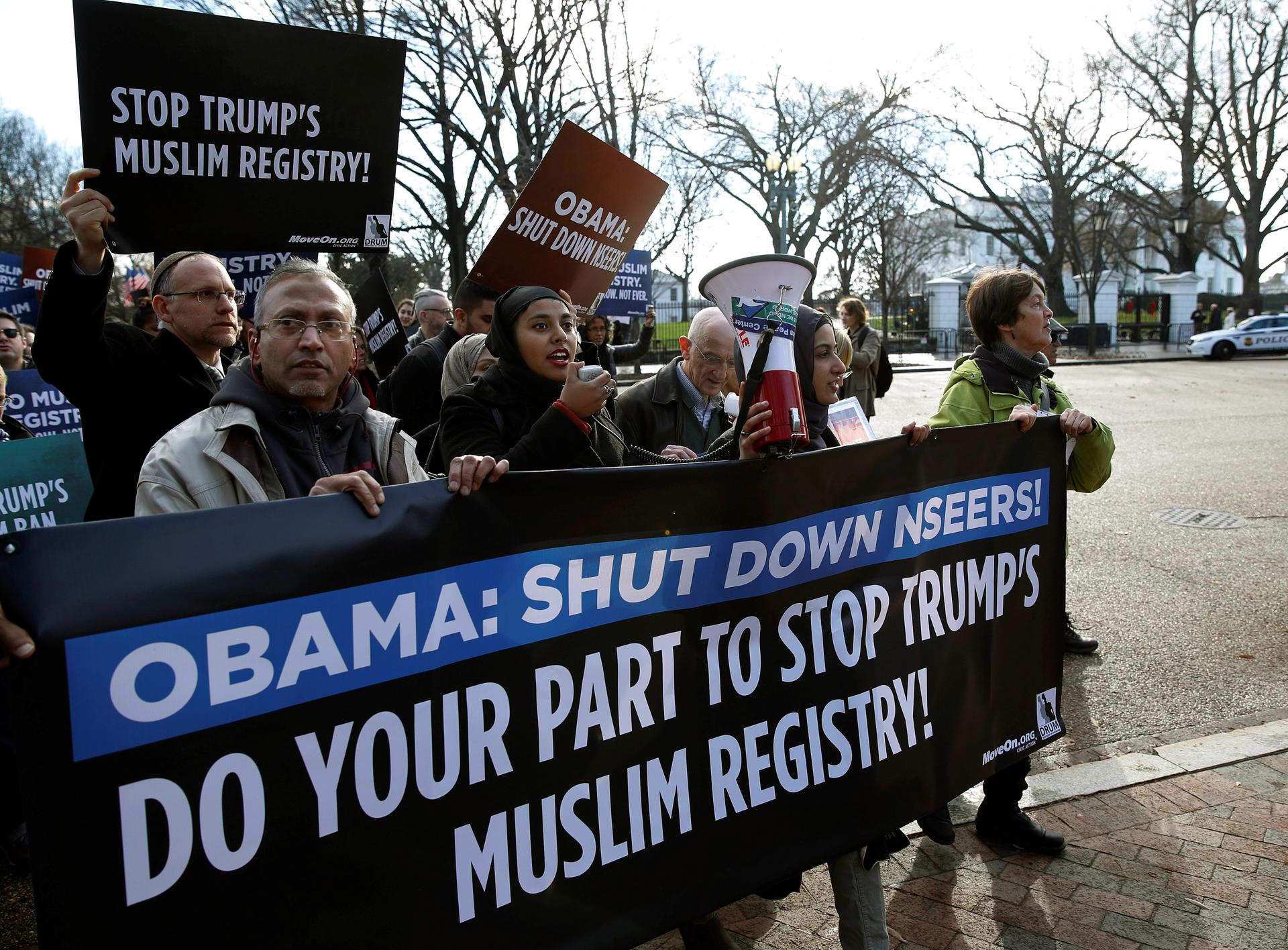 Protesters march with a sign that says "Obama: Shut down NSEERS"
