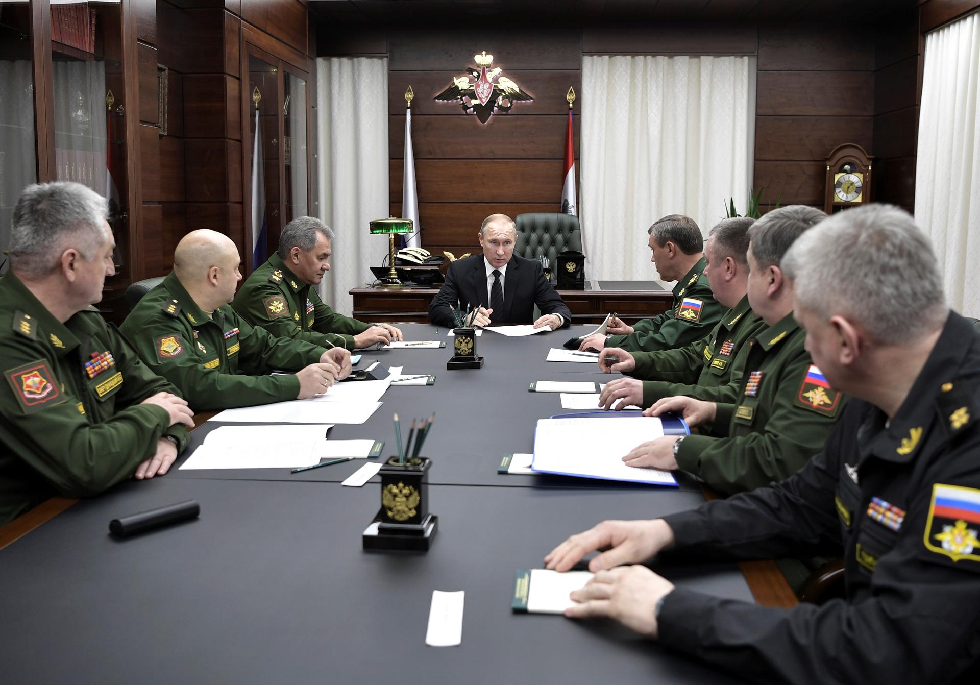 Russian President Vladimir Putin meets with military officials