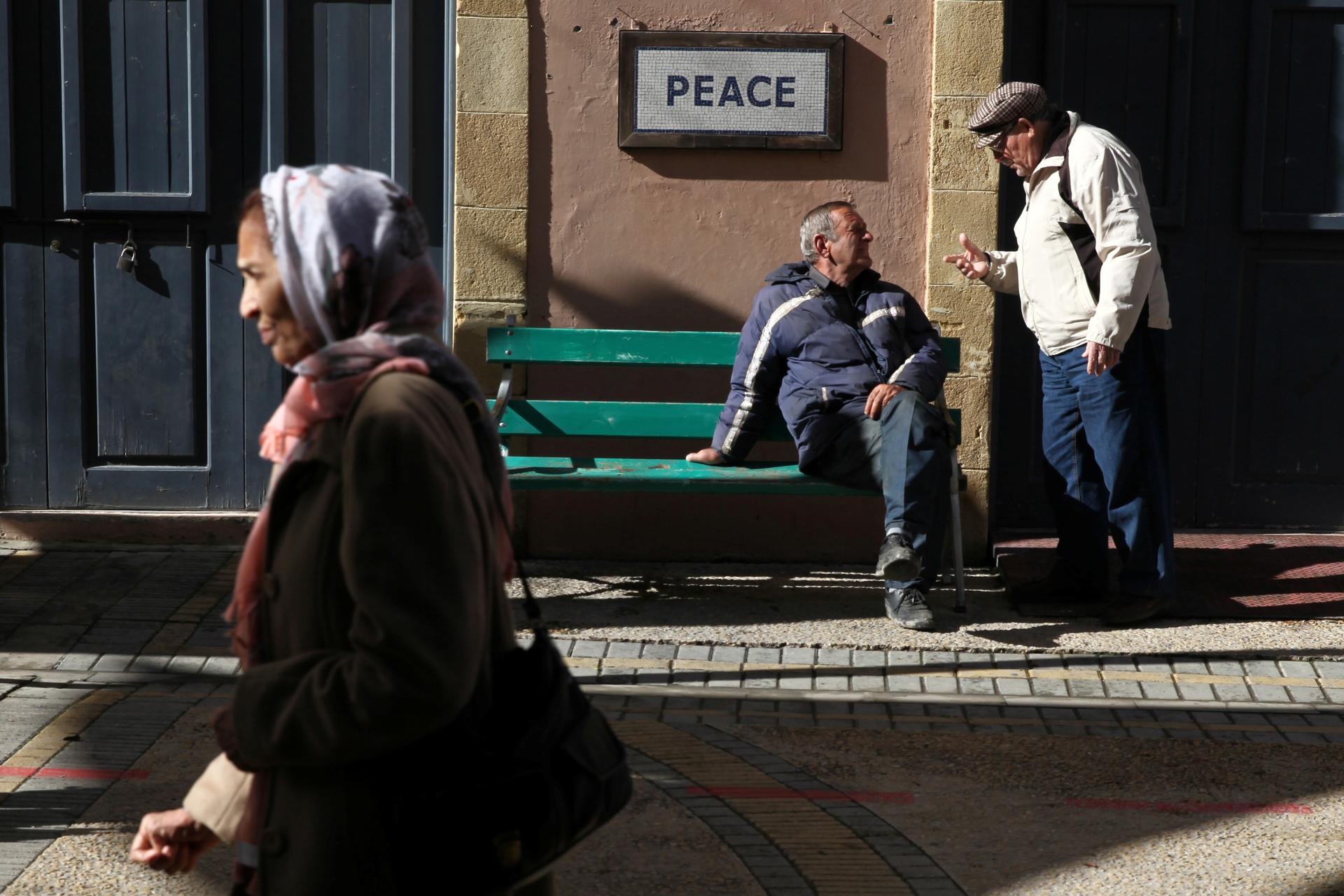 People are seen on Ledras Street next to a peace sign near the UN-controlled buffer zone in Nicosia, Cyprus, January 11, 2017.