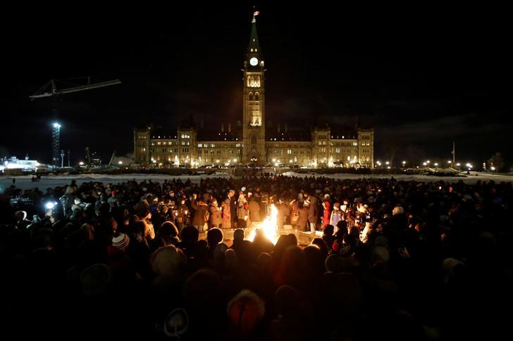 People gather around the Centennial Flame on Parliament Hill during a vigil following a deadly shooting at a Quebec City mosque, in Ottawa, Ontario, Canada, January 30, 2017. 