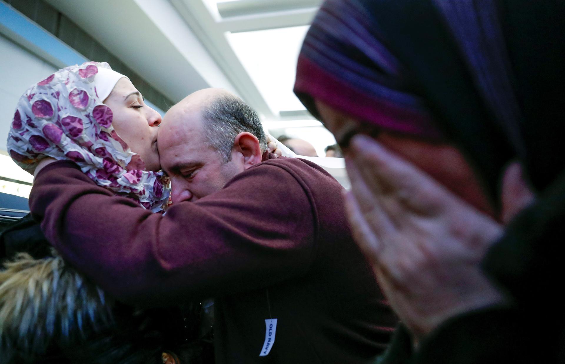 Syrian refugee Baraa Haj Khalaf (left) kisses her father Khaled as her mother Fattoum (right) cries after arriving at O'Hare International Airport in Chicago on February 7, 2017. 