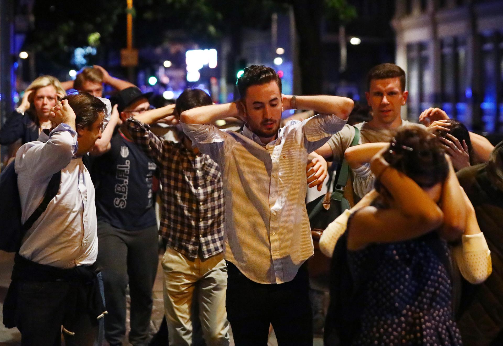 People leave London Bridge area with their hands up after the attack.
