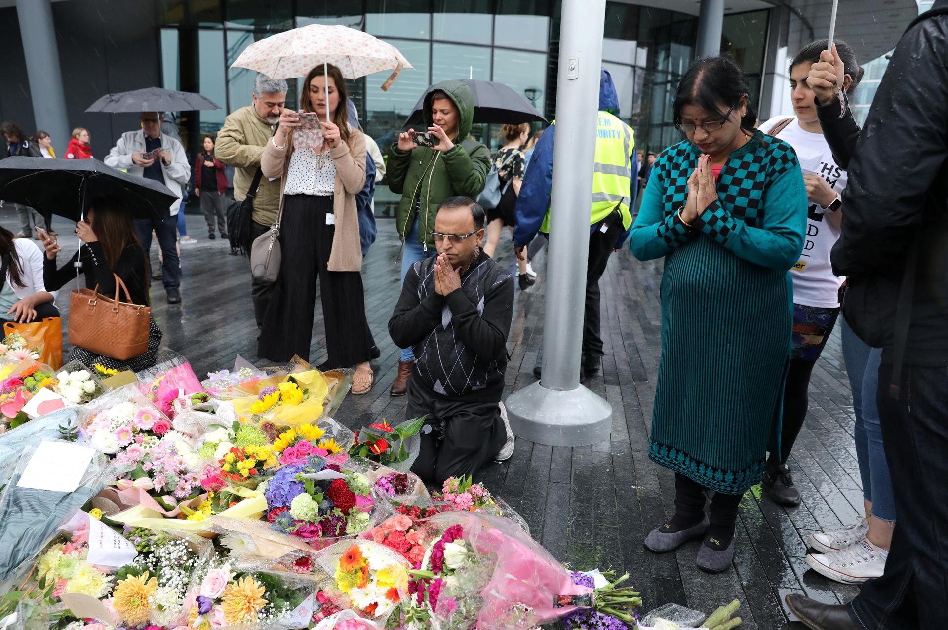 People pray after a vigil to remember the victims of the attack on London Bridge and Borough Market, at Potters Field Park, in central London, Britain, June 5, 2017.