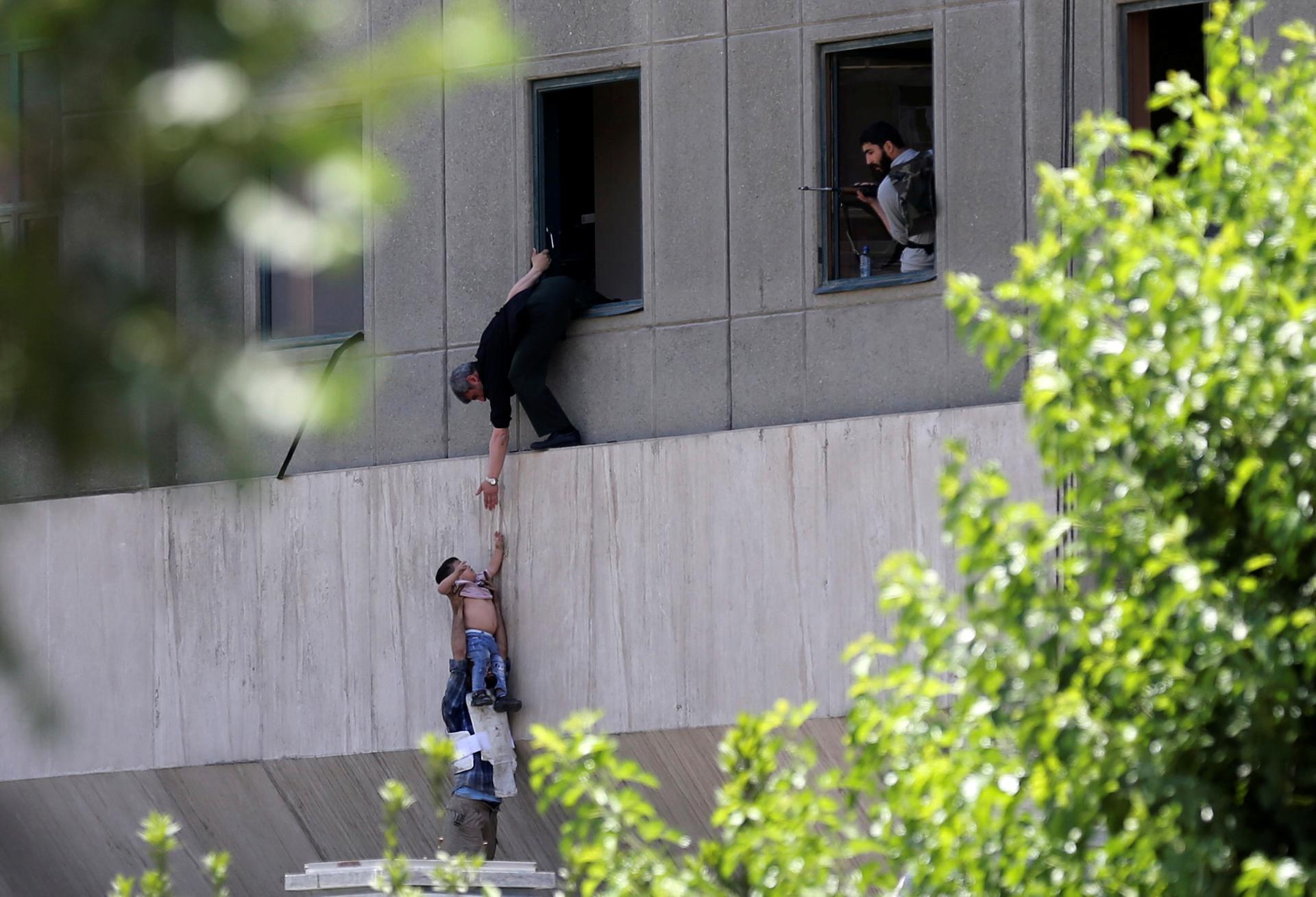 A boy is evacuated during an attack on the Iranian parliament in Tehran, Iran.