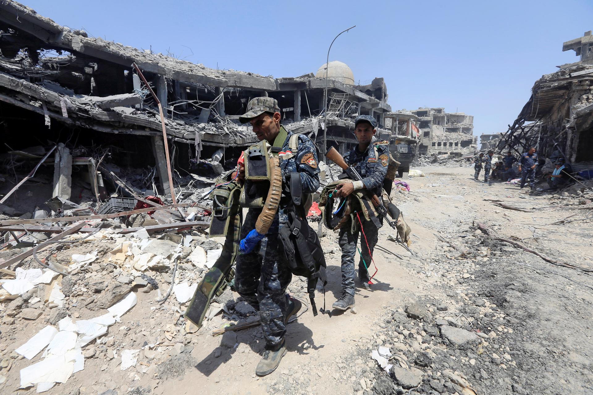 Members of Iraqi Federal police carry suicide belts used by Islamic State militants in the Old City of Mosul. 