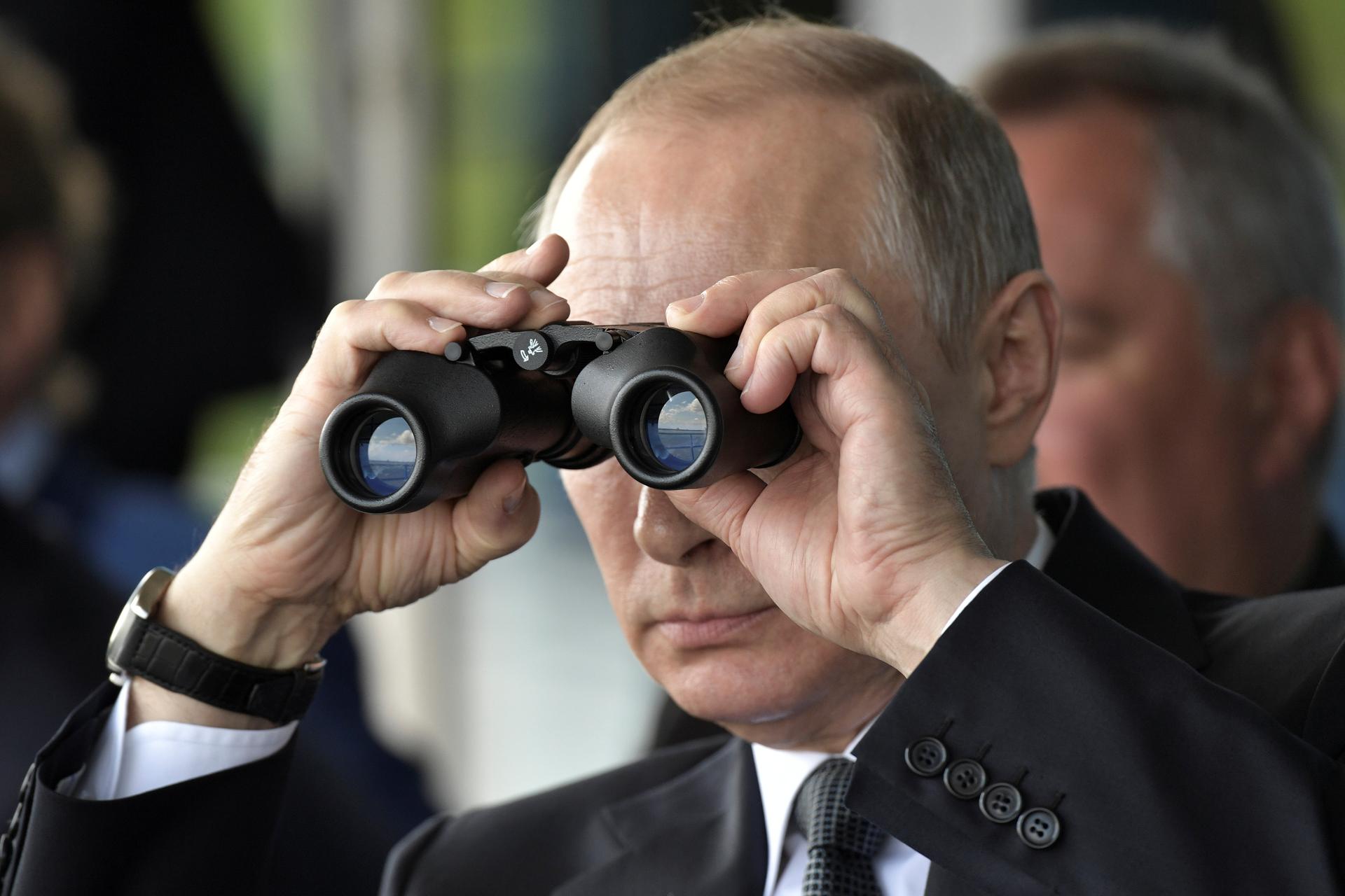Russian President Vladimir Putin uses a pair of binoculars as he watches a display during the MAKS 2017 air show in Zhukovsky, outside Moscow.