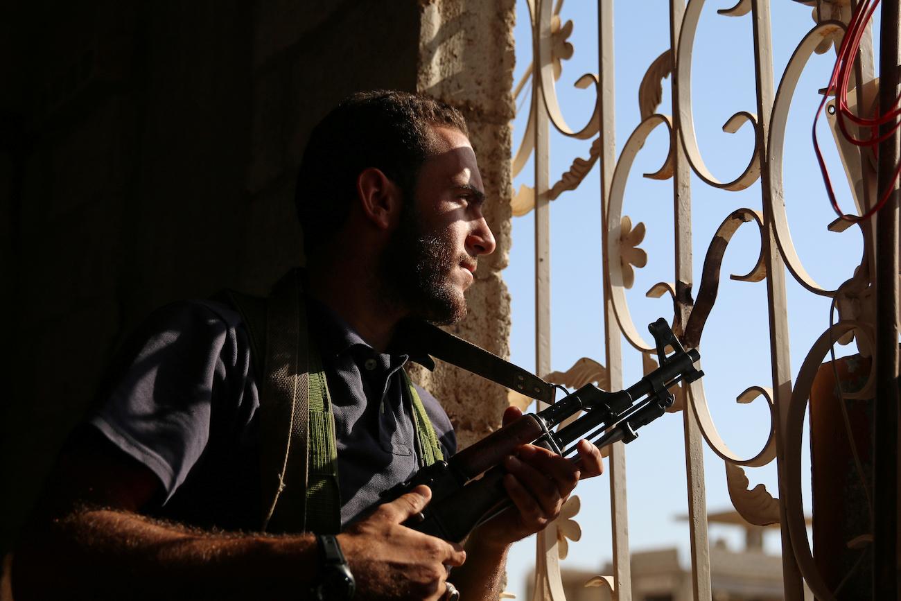 A Free Syrian Army fighter looks out through a window in rebel-held Al-Yadudah village, in Deraa Governorate, Syria, on July 19.