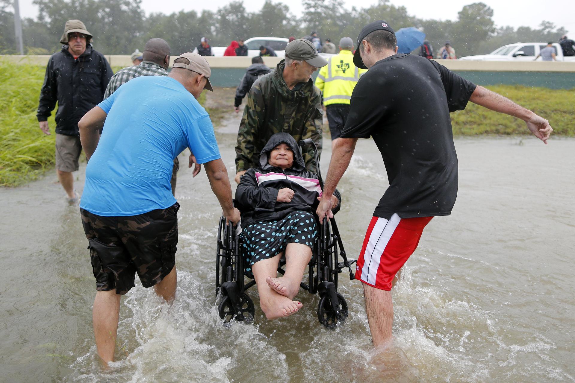 An elderly woman in a wheelchair is rescued from the flood waters of tropical storm Harvey in east Houston, Texas.