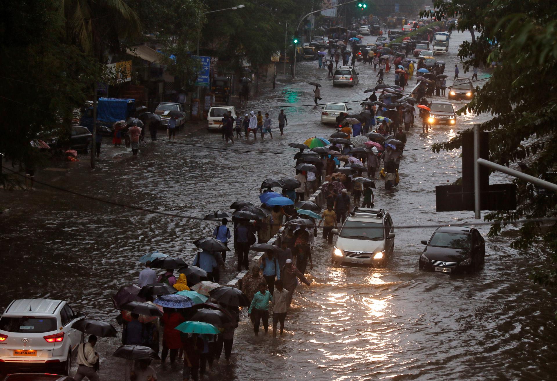 Commuters walk through water-logged roads after rains in Mumbai.