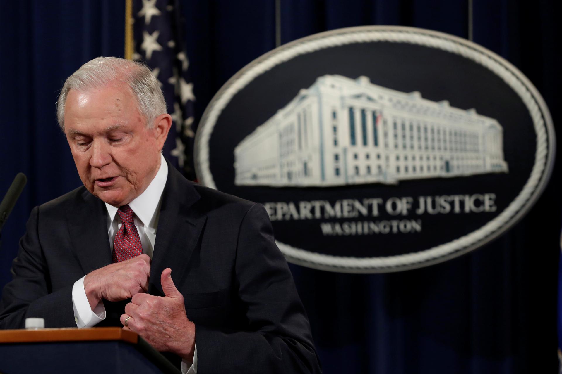 Man at podium with Department of Justice insignia behind him