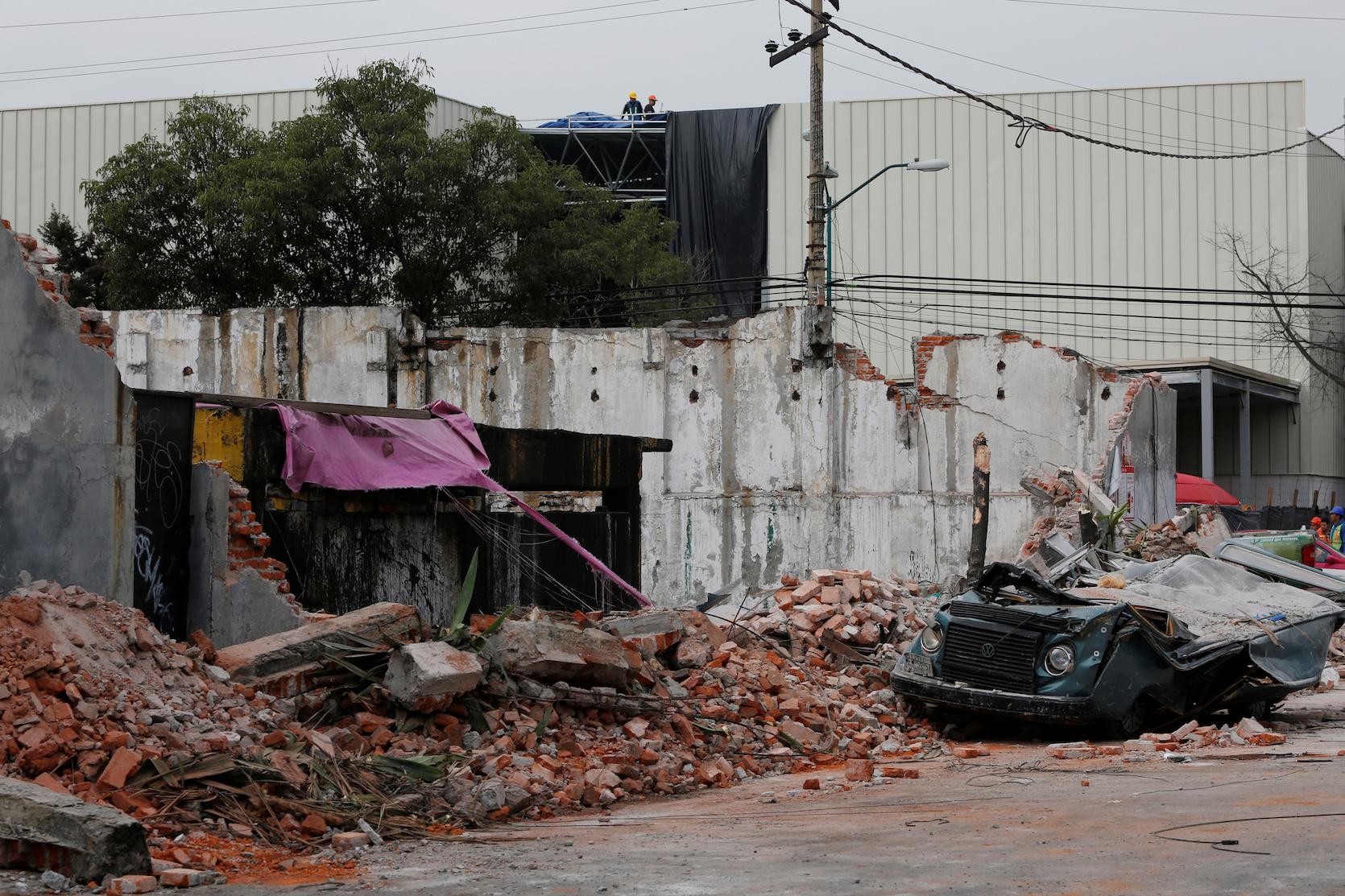 A damaged wall and a smashed vehicle are pictured after an earthquake in Mexico City on Sept. 8, 2017.