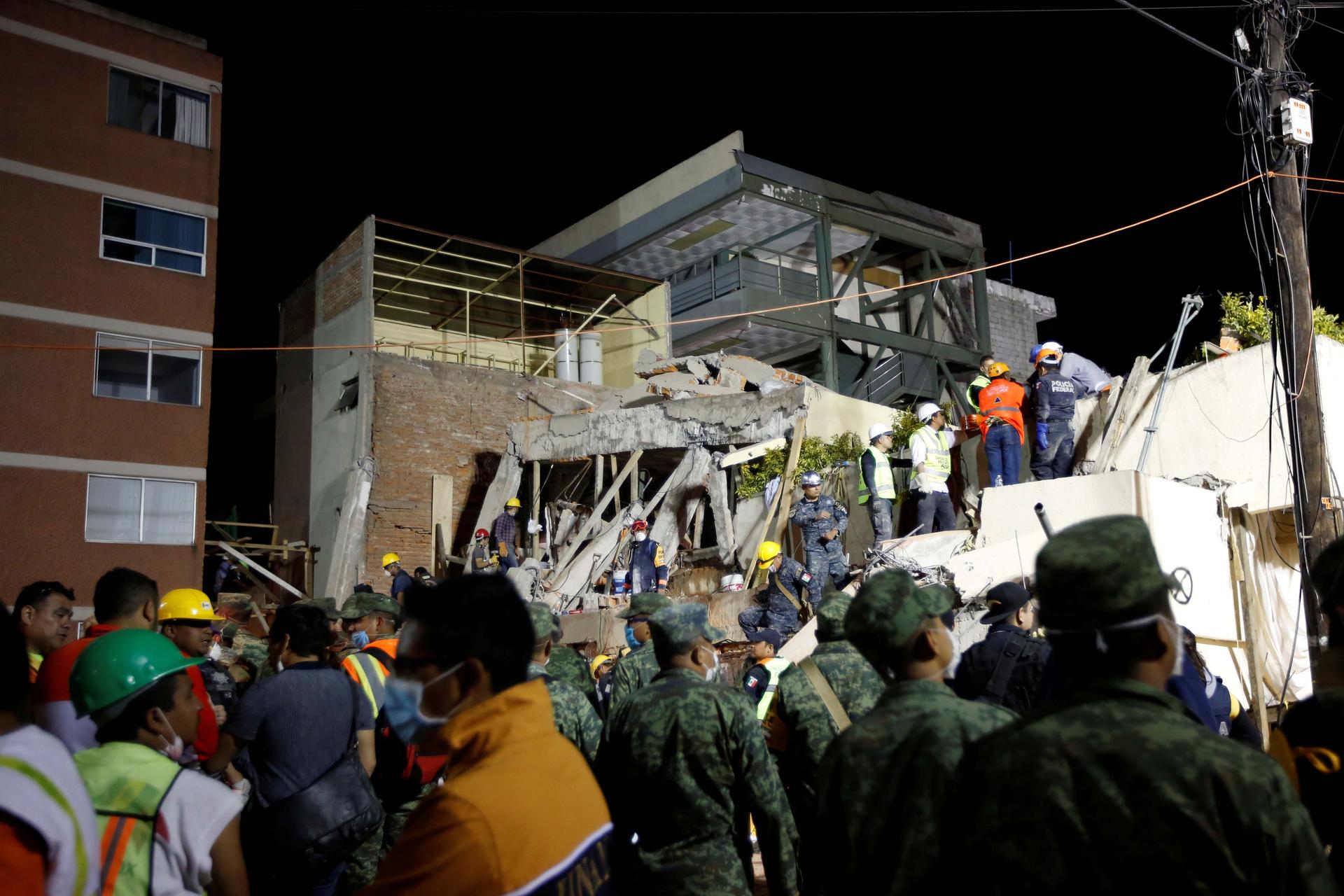 Rescue workers search through rubble during a floodlit search for students at Enrique Rebsamen school in Mexico City on Sept. 20, 2017.