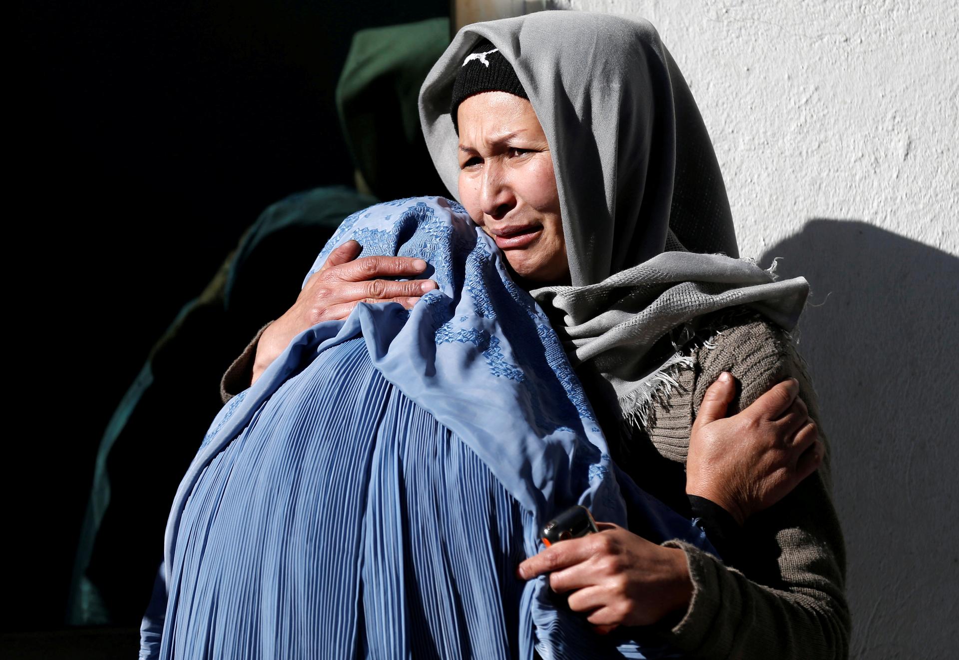 Afghan women mourn inside a hospital compound after a suicide attack in Kabul,