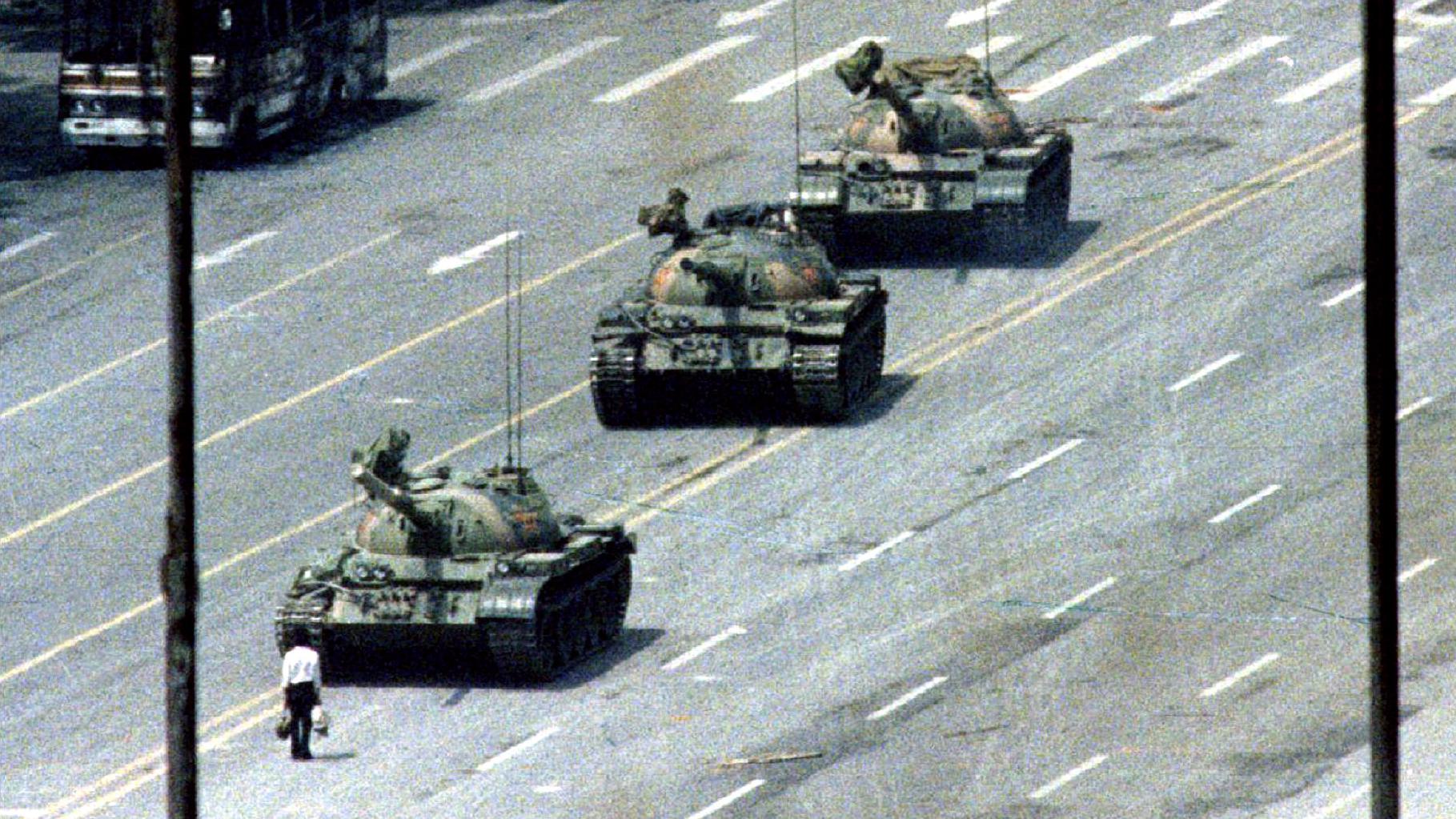 The famous 'tank man', alone and unarmed, stands passively in front of a convoy of tanks on the Avenue of Eternal Peace in Tiananmen Square on June 5, 1989. The iconic image is banned in China but has permeated popular and protest culture around the globe