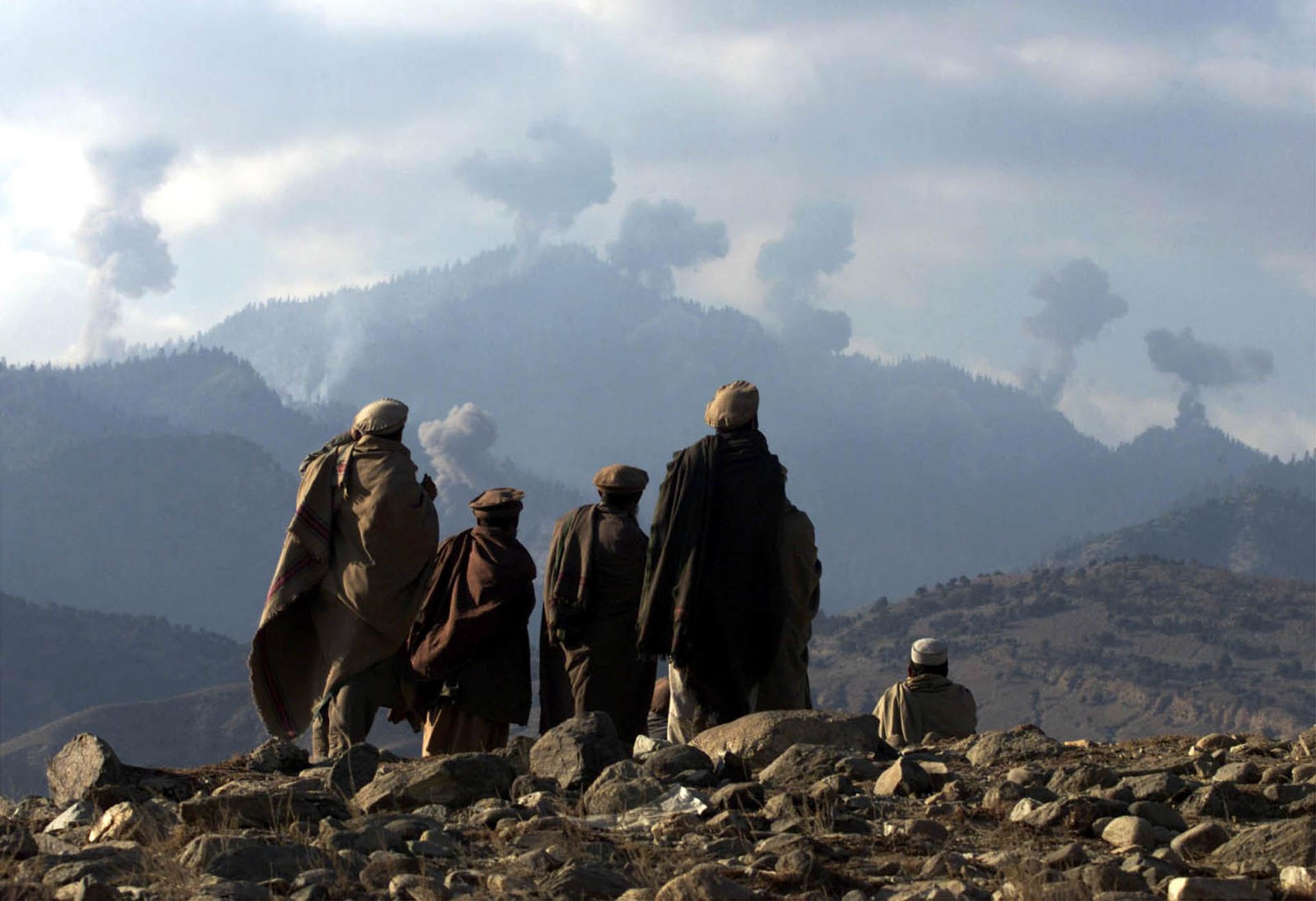 Anti-Taliban Afghan fighters watch several explosions from U.S. bombings in the Tora Bora mountains in Afghanistan December 16, 2001