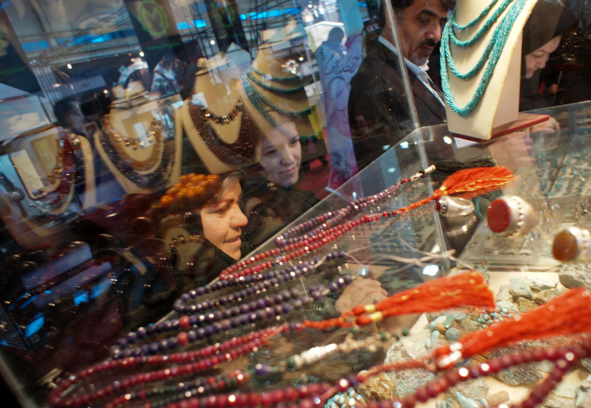 Women gaze at jewelery displayed at an international fair in Tehran.