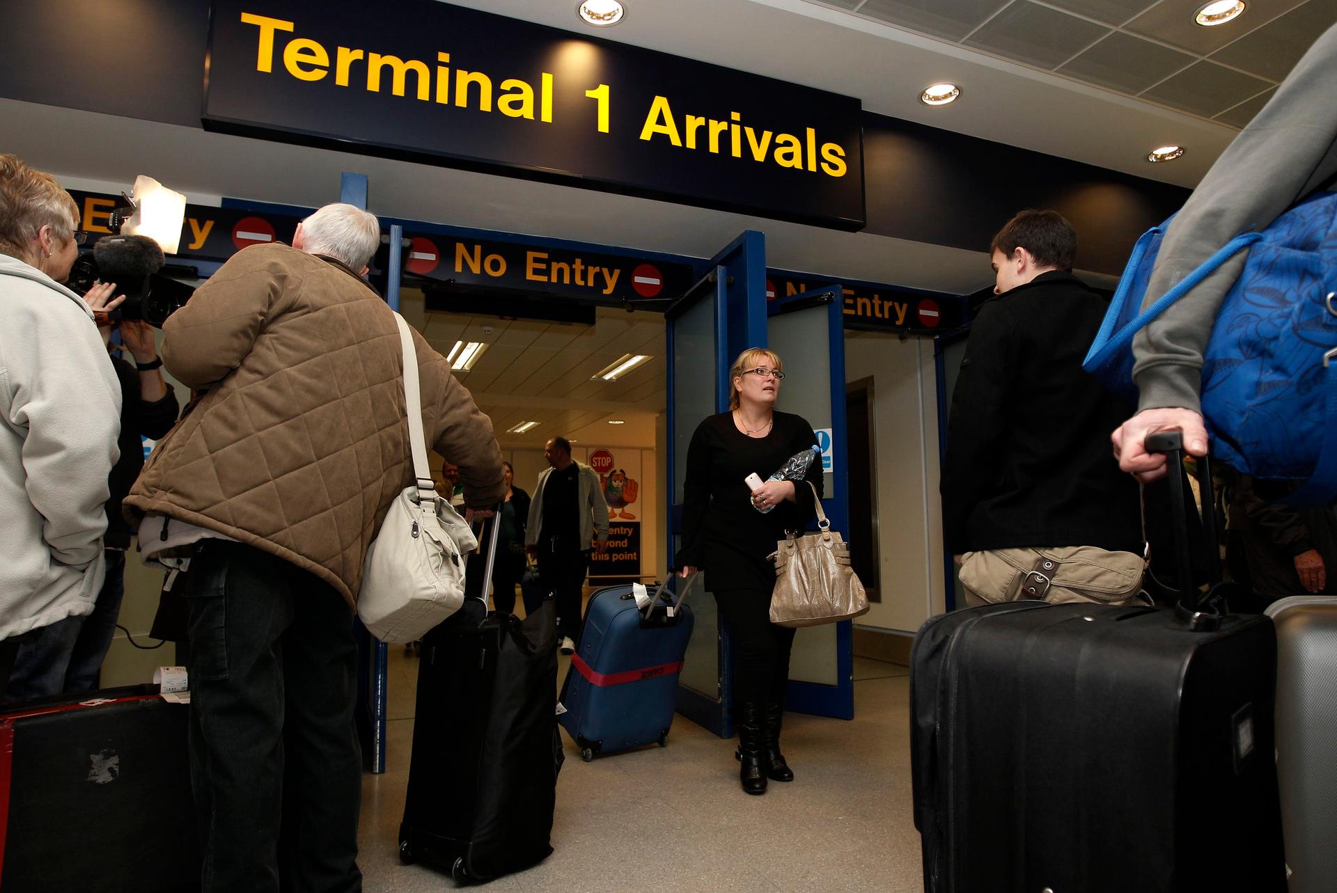 Holiday makers returning from Tunisia walk through the arrivals section at Manchester Airport in Manchester, northern England, January 14, 2011.