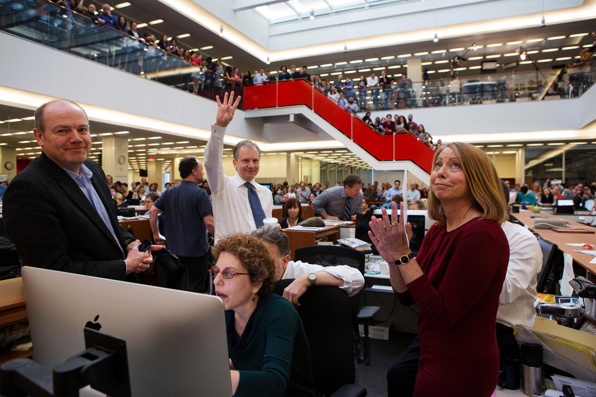 Publisher Arthur Sulzberger Jr. holds up four fingers to indicate the four Pulitzer Prizes won by the New York Times in 2013 as Executive Editor Jill Abramson looks on.  