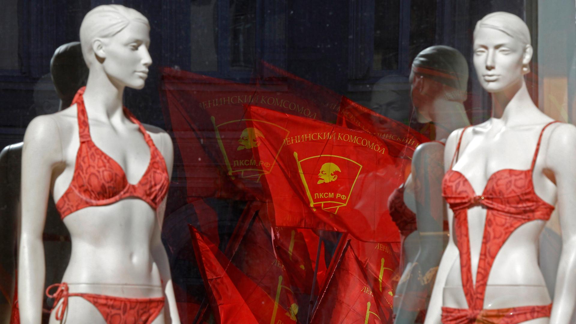 Communist flags are reflected in a lingerie shop window during a traditional Labor Day march in St. Petersburg in 2013.
