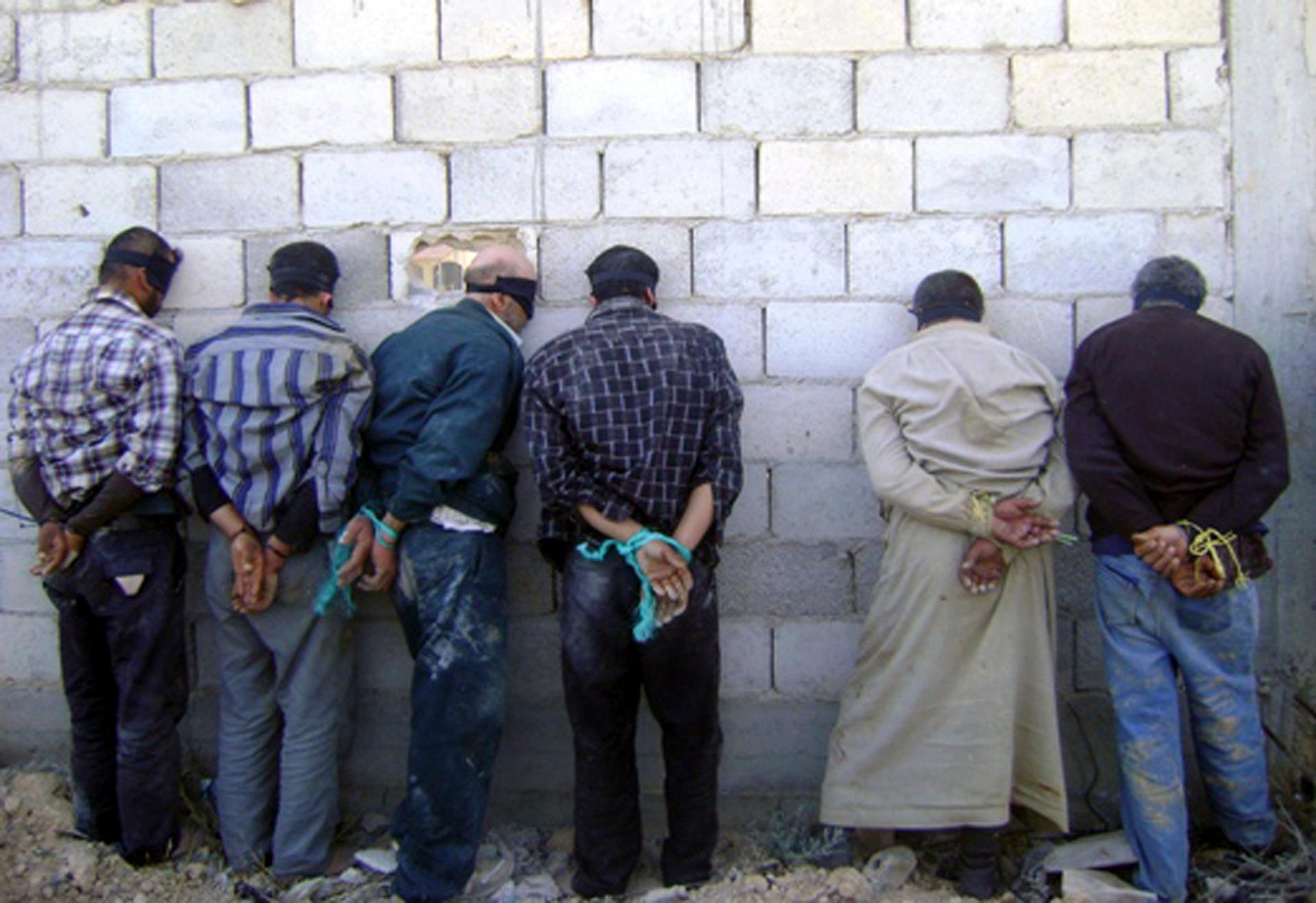A handout photograph distributed by Syria's national news agency SANA shows detained men, blindfolded and handcuffed.